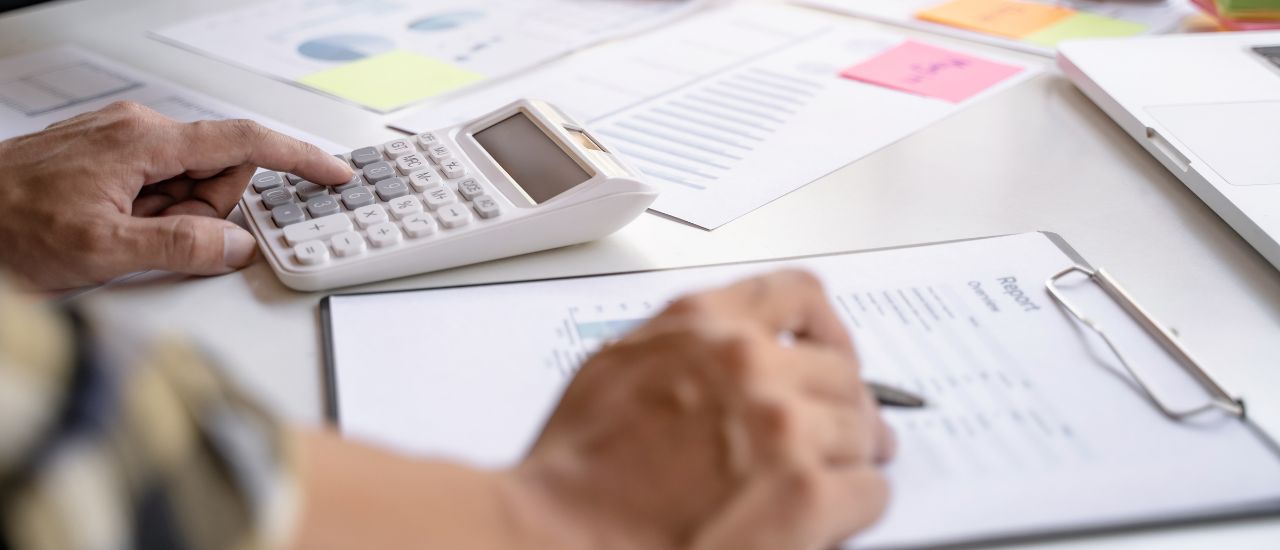 Photo of a man with calculator on paper to represent business audit